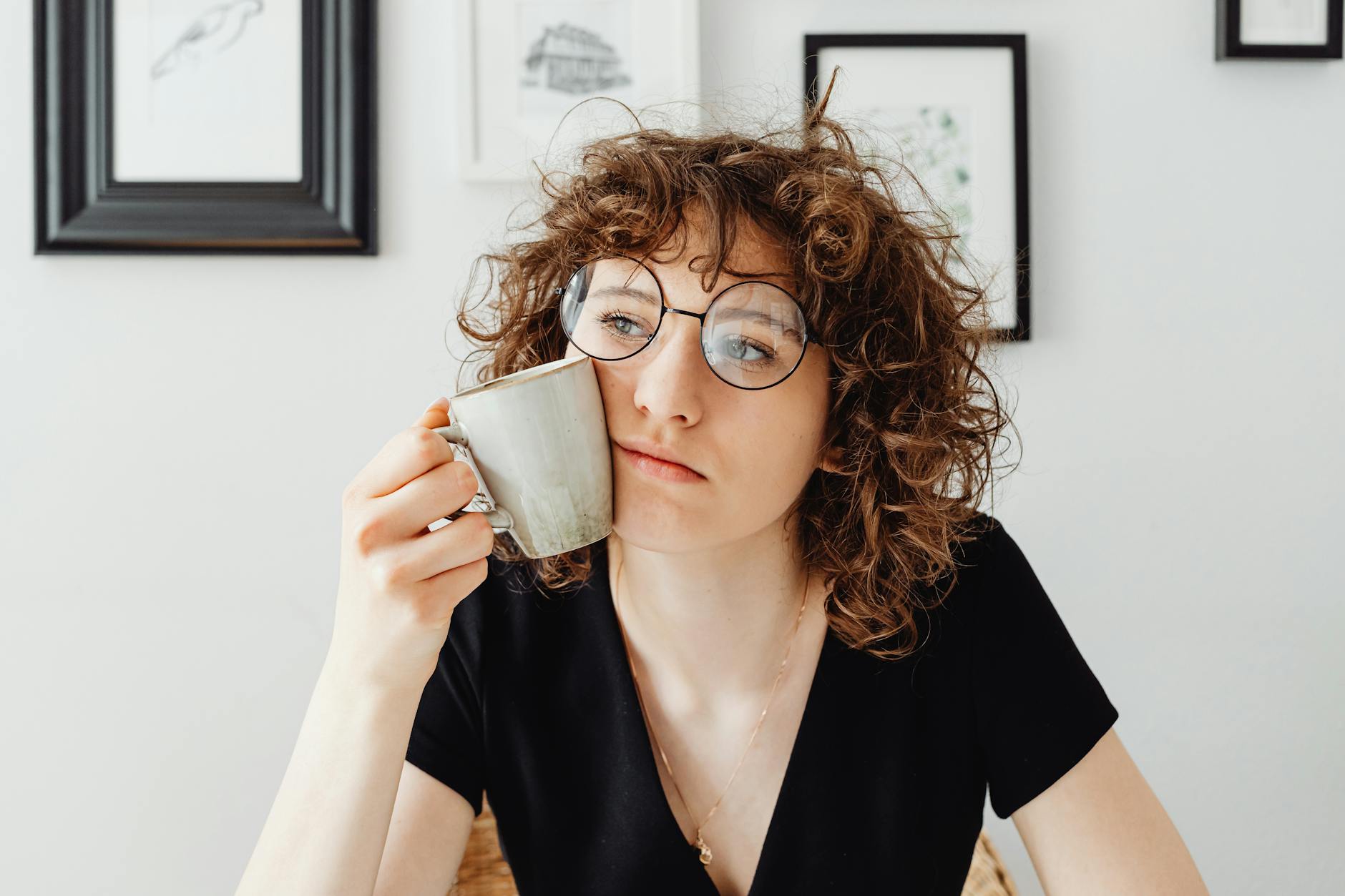 curly haired woman holding a coffee mug