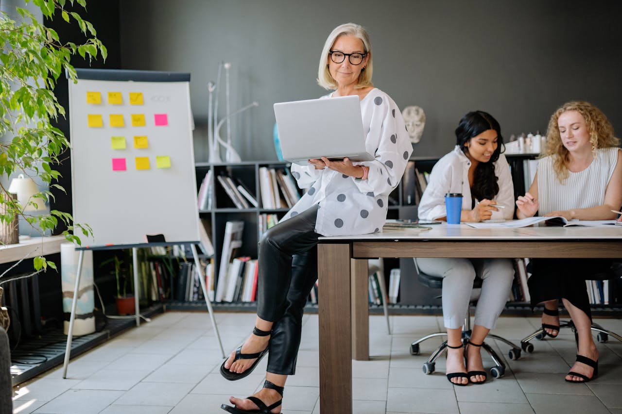 Diverse women team collaborating in a stylish office setting with technology and brainstorming tools.