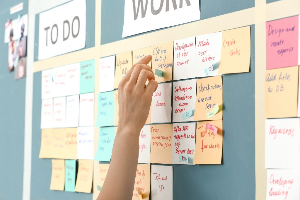 Silke Mekat Effizient arbeiten, gelassen leben: Trainerin & Coach für Zeitmanagement, Selbstorganisation & Stressprävention – für ein souveränes Berufs- und Privatleben.AdobeStock_251298381 young woman near scrum task board in office